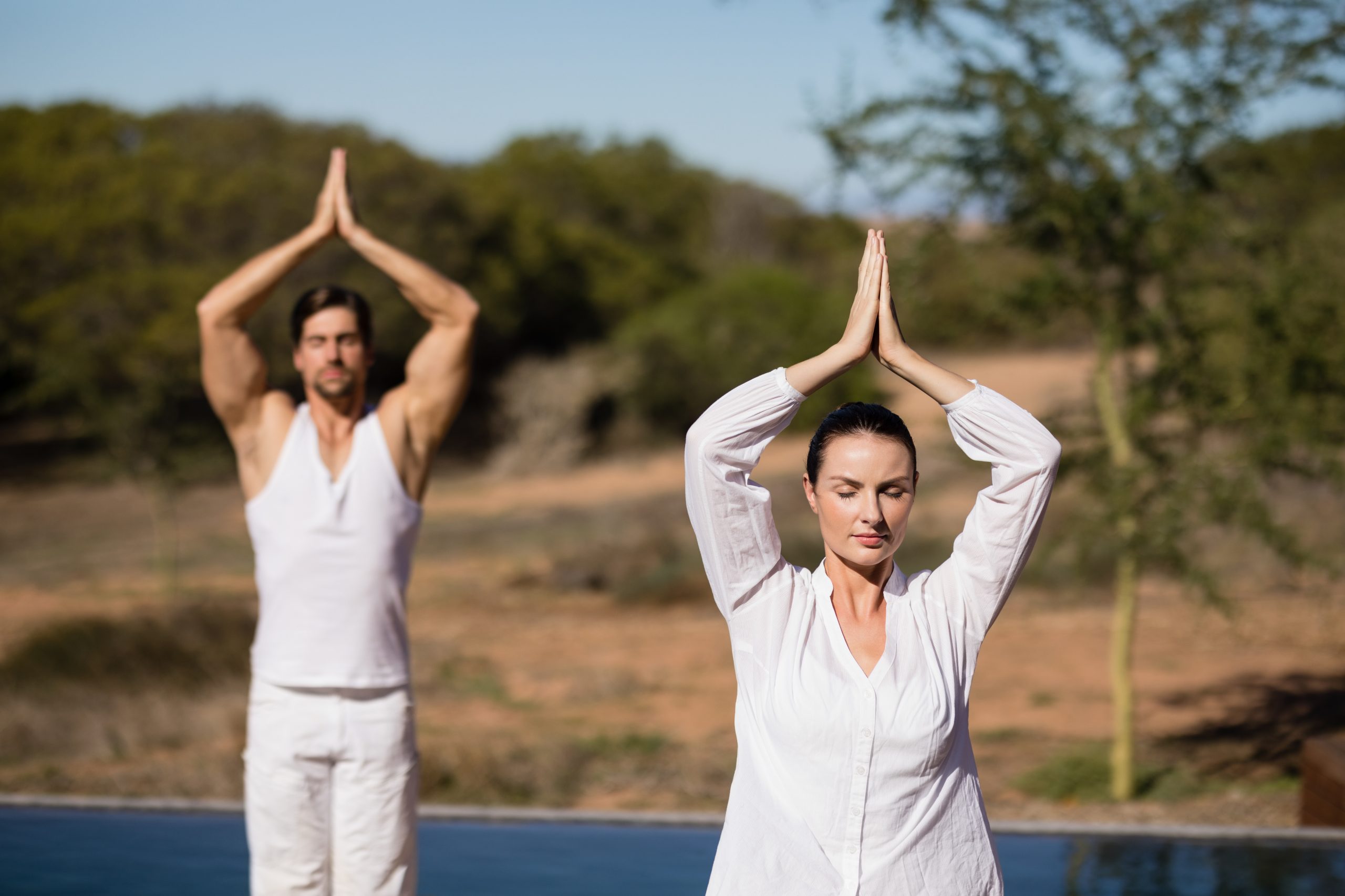 couple performing yoga safari vacation scaled